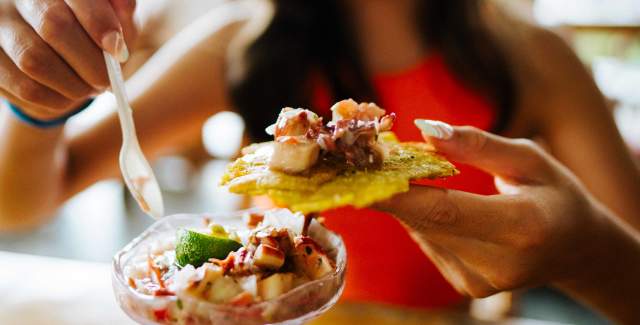 Close up of Woman eating ceviche with patacones